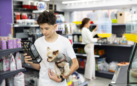 Preteen boy selecting dry dog food for Yorkie in pet store