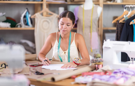 female dressmaker deals with documents in the atelier