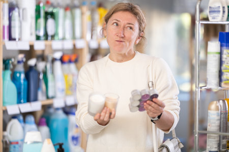 Female shopper chooses scented candles in supermarket for romantic eveningの写真素材