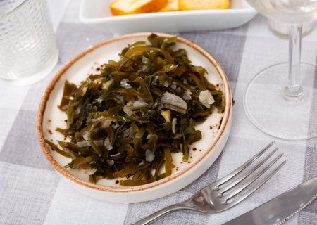 Portion of just cooked salad made of sea cabbage and onion