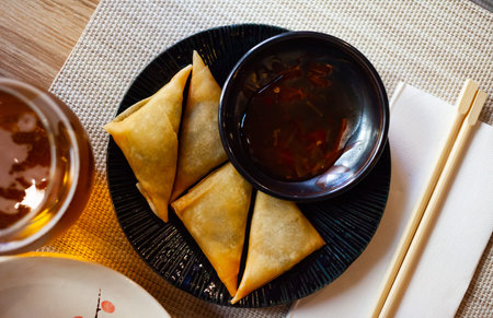 Potato curry samosas served with sauce at plate
