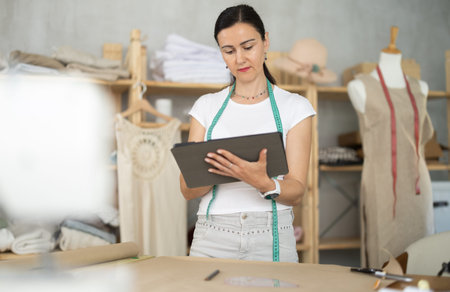 Woman dressmaker makes pattern using tablet