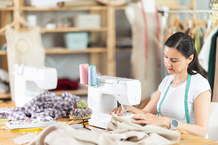 Woman tailor sews clothes in sewing machine