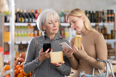 Elderly mother and her adult daughter scan a QR code on a cheese label together to check expiration...