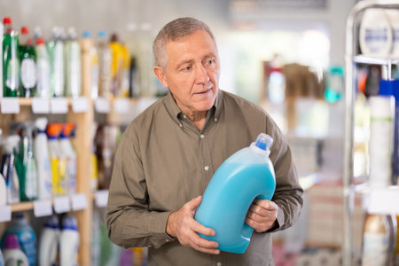 Mature man choosing a cleaning productの写真素材