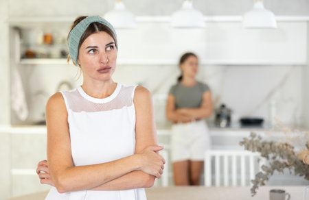 Serious woman is standing in kitchen and thinking about somethingの写真素材