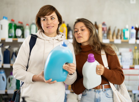 Mother and her adult daughter choose detergent together in household supermarketの写真素材