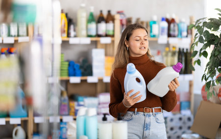 Young woman choosing laundry detergent in department storeの写真素材