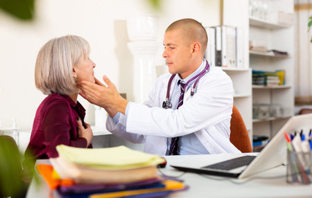 Therapist examining female patient complaining of sore throat