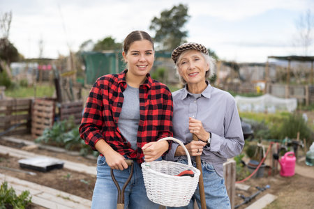 Portrait of positive young woman with an elderly mother after gardeningの写真素材