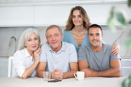 Portrait of a happy family of four sitting together at kitchen table