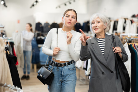 Elderly and young women walk through clothing storeの写真素材