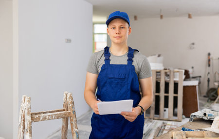 Hardworking fifteen-year-old worker makes notes on paper