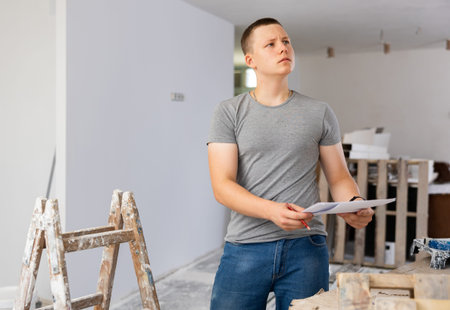 Teenager boy inspecting building site inside apartment