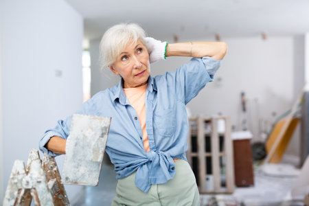 Mature woman working on home renovationの写真素材