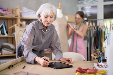 Mature Fashion Designer Drawing Mockup On Tabletの写真素材