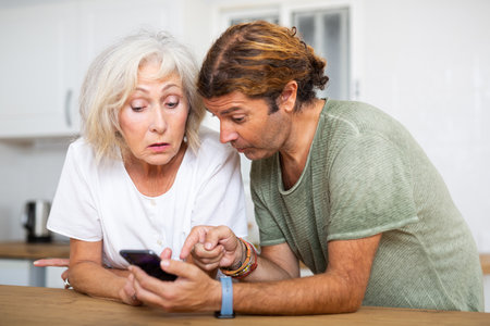 Husband help an elderly wife learn how to use smartphoneの写真素材