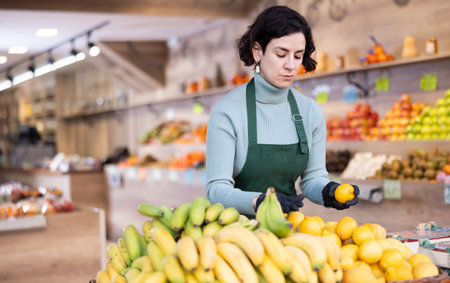 Woman shop seller puts lemon goods on display caseの写真素材