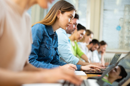 Side view of group of adult students in university classroom
