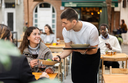 Waiter guy brought a ready-made order in a restaurantの写真素材
