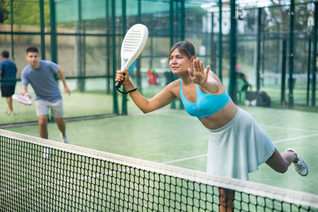 Attractive woman padel tennis player training on courtの写真素材