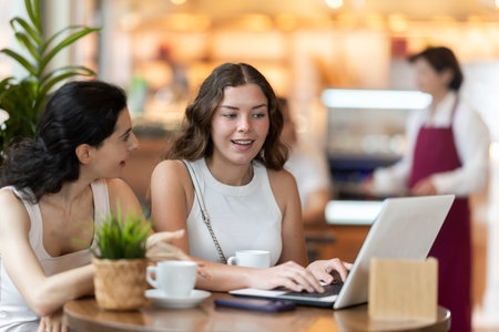Two freelancers girls in cafe with laptop drinking coffeeの写真素材