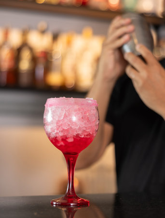 Bartender serving tequila sunrise cocktail at bar