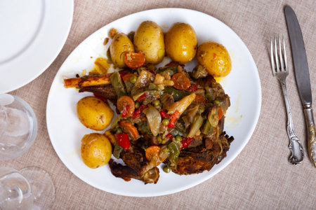 Mutton leg baked with vegetables served with side dish of boiled potatoes.の写真素材