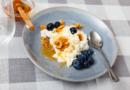 Farm cottage cheese filled with large amount of honey with walnut and blueberry.の写真素材