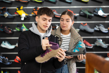 Couple examine view several item of winter comfortable trecking shoesの写真素材