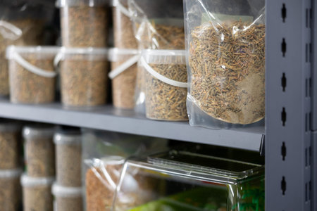 On shelf in pet store there are containers of various weights and capacities with dry food for...