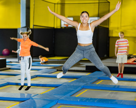 Happy girl bouncing on trampoline in indoor amusement park