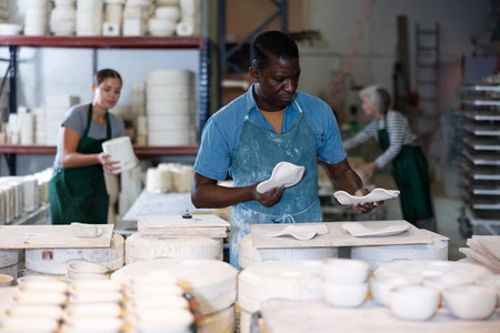 Man ceramist working in pottery workshop