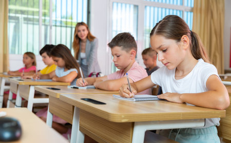 Schoolgirl sitting in classroom during lesson in elementary school