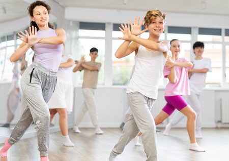 Group of teenagers learn to dance hip-hop and other modern dances in spacious dance studio