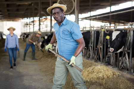 African male farmer in strow hat working in stall