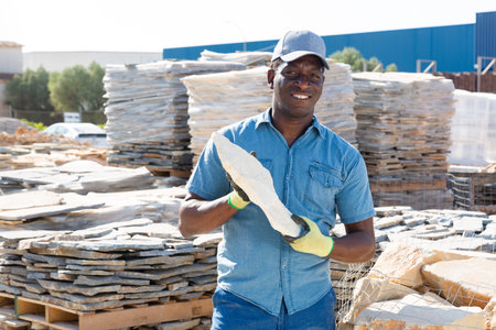 Afro worker posing with natural stone tile