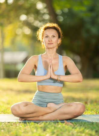 Adult woman doing yoga in lotus positionの写真素材