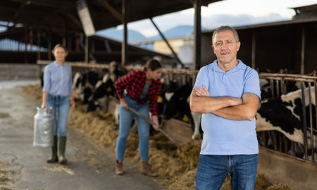 Positive man farmer in cowshed
