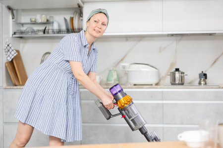 Housewife does cleaning in room - vacuums and dustsの写真素材