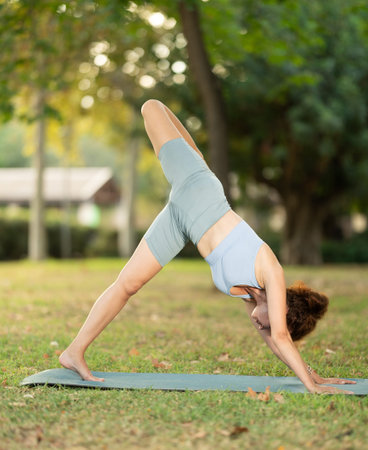 Adult woman doing yoga in park