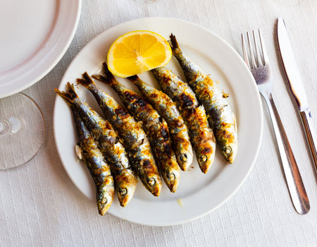 Malaga traditional fried on skewers sardines on plate on wooden tableの写真素材
