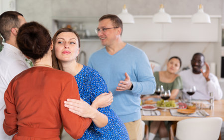 Married couples meet at home for festive dinner. Greet each otherの写真素材