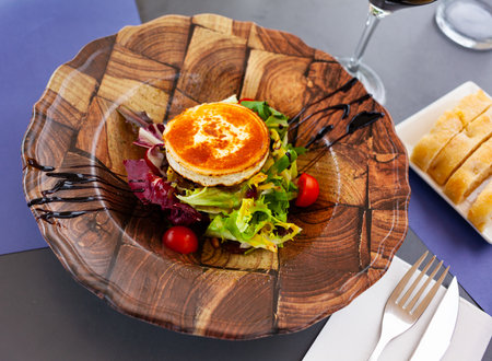 Appetizing salad with goat cheese, tomatoes and walnuts on plateの写真素材