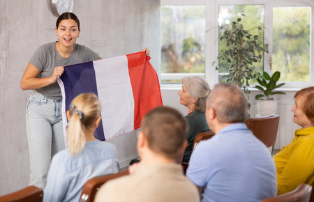 Geography lesson - teacher talks about France, holding flag in her handsの写真素材