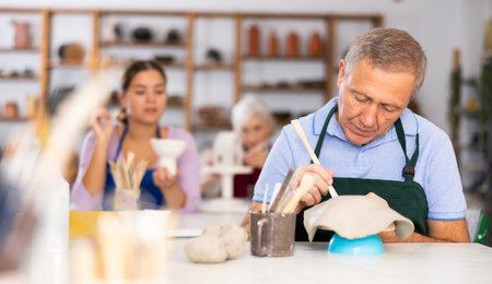 elderly potter is working with clay billetの写真素材