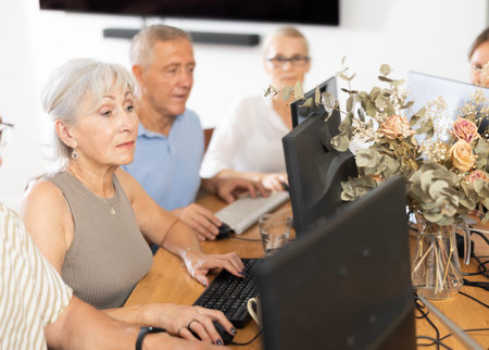 Group of older people studying on computer course
