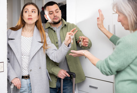 Couple returning keys to woman at doorwayの写真素材