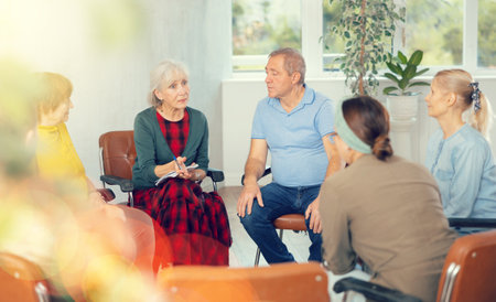 Senior female tutor leading educational class for elderlyの写真素材