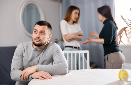 Man waiting for two women stop quarrelingの写真素材